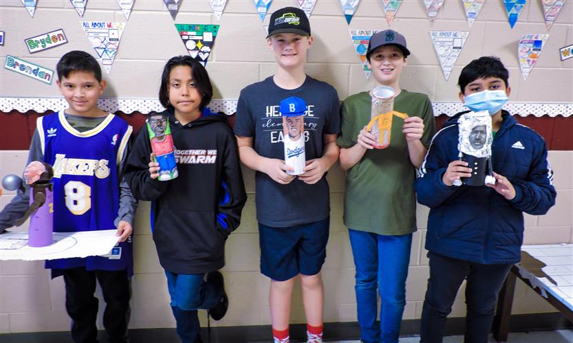 Students hold up Characters in a Can
